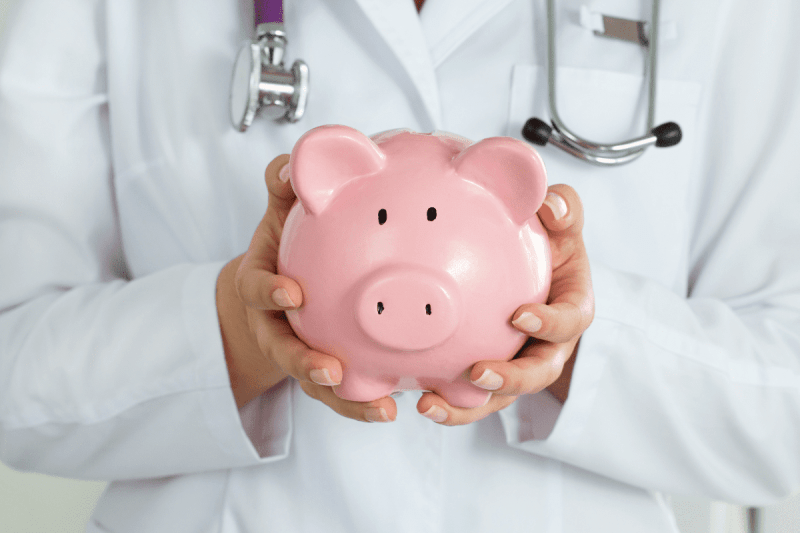 Doctor holding piggy bank to represent healthcare savings
