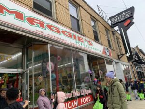 The storefront of Maggie's, a brick building with a colorful awning.