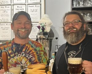 The two owners of TwoGuys sporting beer foam in their mustaches and beards.