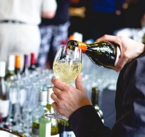 A wine glass is being filled with crisp white wine.