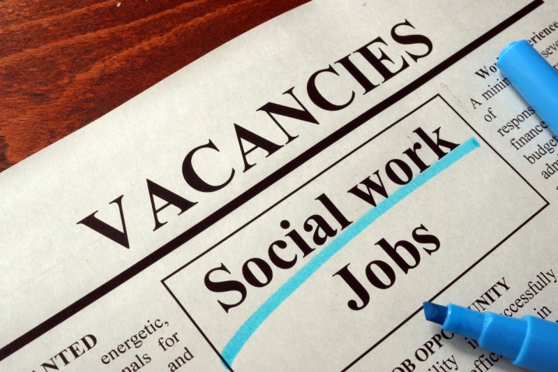Social Workers. Newspaper reading Social Work Job Vacancies.