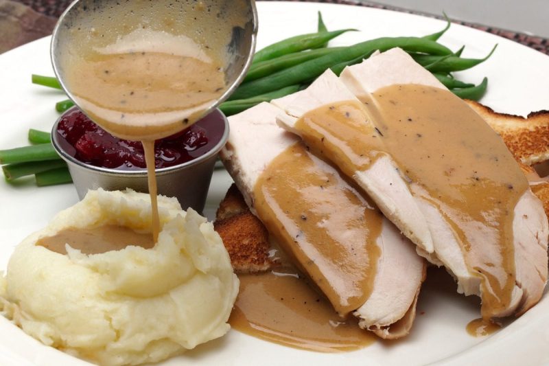 Dine-in Thanksgiving meal on plate. Hot turkey sandwich which gravy and mashed potato