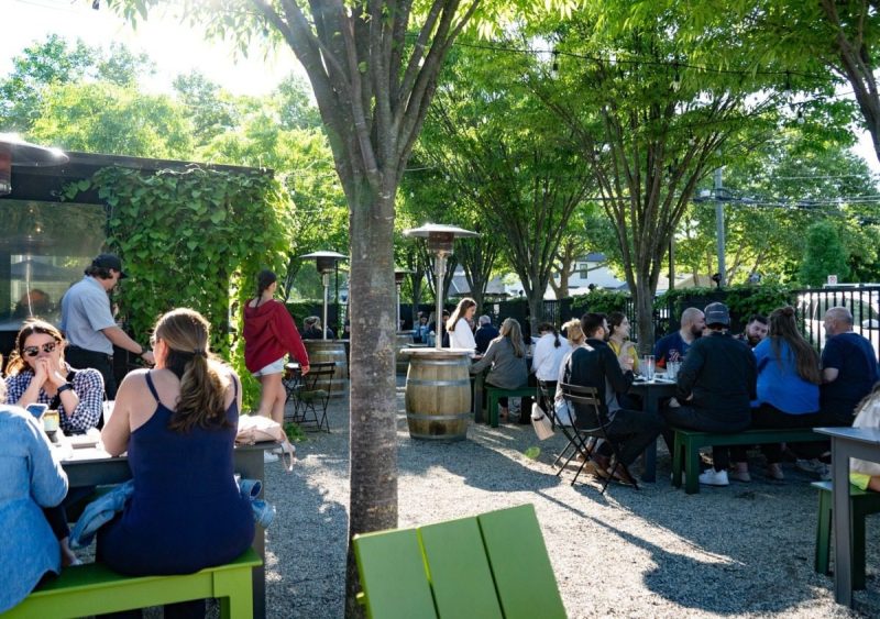 folks sitting outdoors enjoying beers together