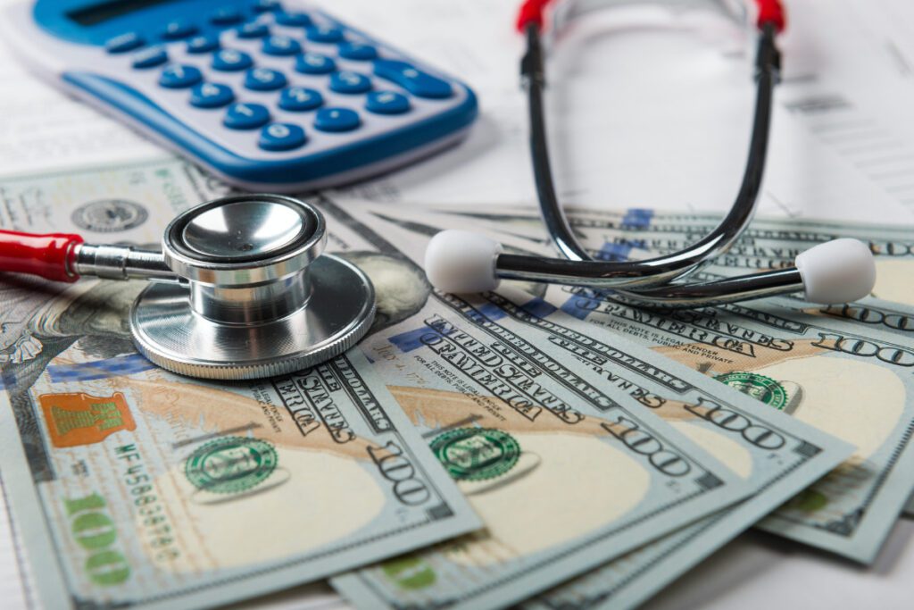 One Big, Beautiful Bill Act. Pile of Money next to calculator, stethoscope