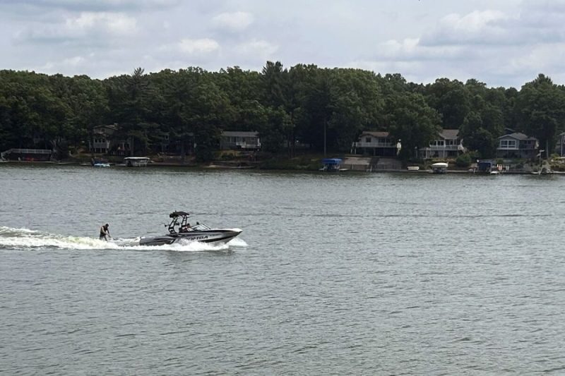 A wake boat tugging a wakeboarder cuts across Brooks Lake on a recent weekend afternoon.