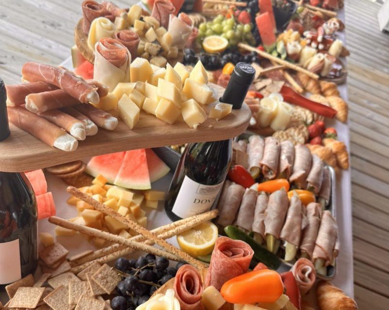 A charcuterie table with a bottle of wine in the center, from Amore Trattoria Italiana, the best restaurant in Grand Rapids