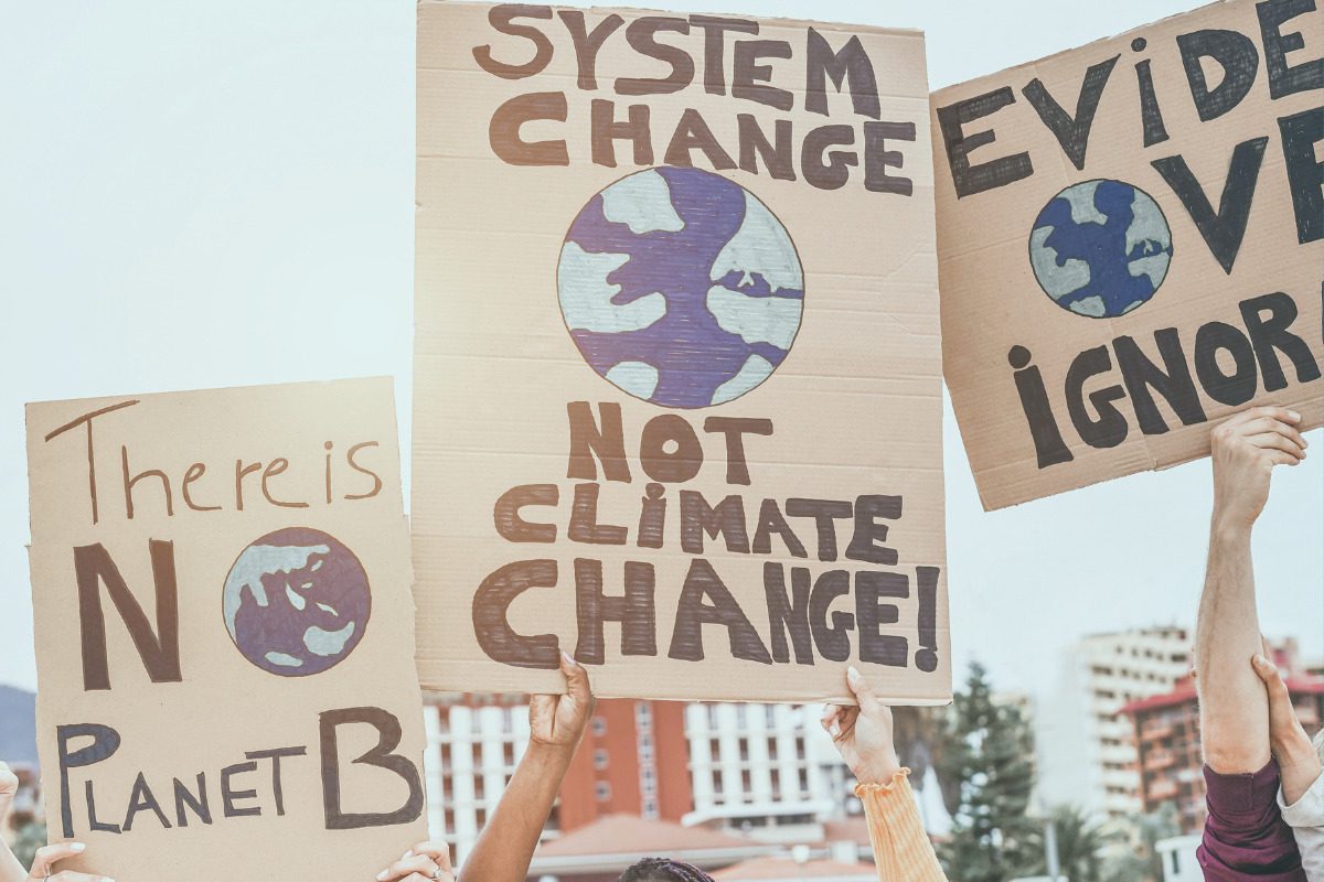 Earth day protests. Group of demonstrators on road, young people from different culture and race fight for climate change - Global warming and enviroment concept - Focus on banners View more by DisobeyArt from Getty Images