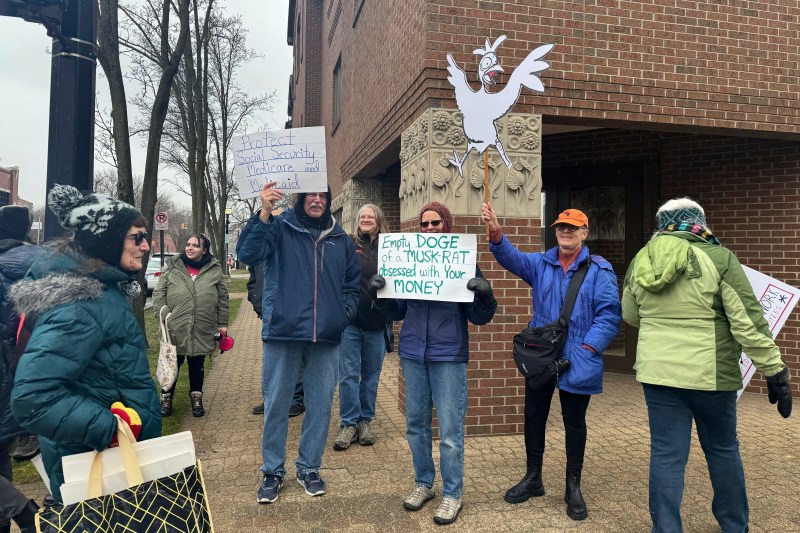 Protesters gather outside Rep. Bill Huizenga's office in Holland, Michigan.
