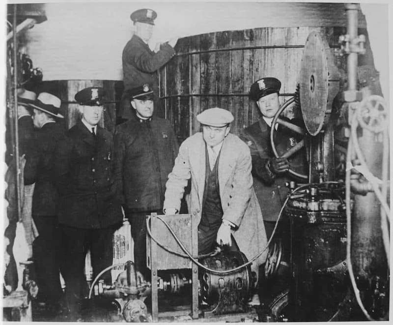 Prohibition-era Detroit police officers confiscate equipment in an “underground brewery."