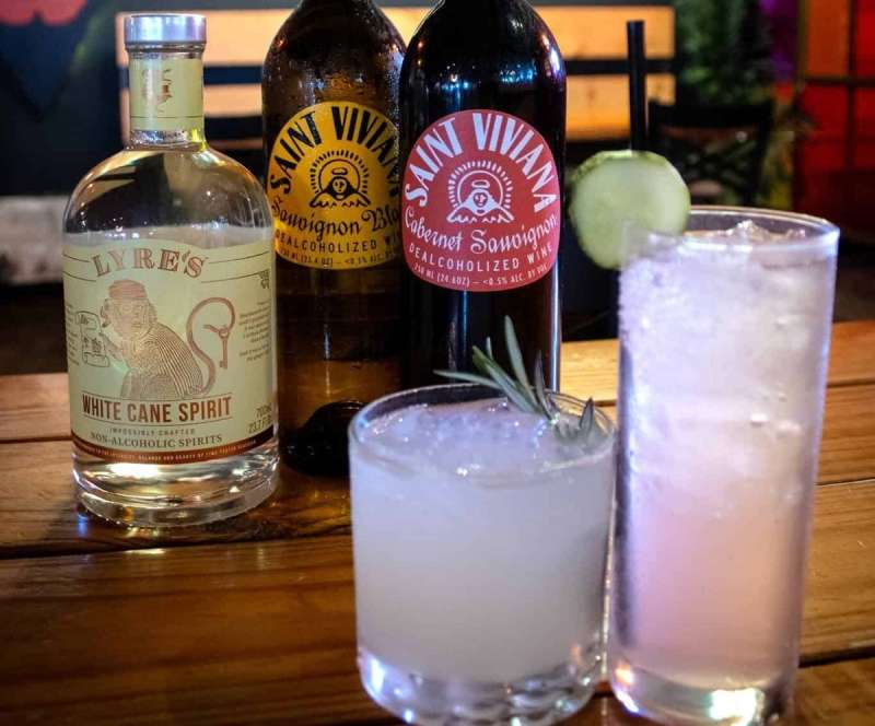 Bottles of mixers sit behind a couple of mocktails in Lansing