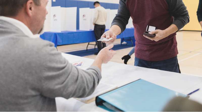 Volunteer checks ID for voter (SDI Productions/Getty Images Signature)
